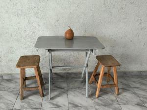 an apple sitting on top of a table with two stools at Casa Tonatih in Mexico City