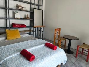 a bedroom with a bed with red pillows and a table at Casa Tonatih in Mexico City