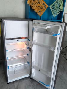 an empty refrigerator with its door open in a kitchen at Casa Tonatih in Mexico City