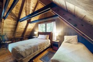 a attic bedroom with a bed and a window at Cabin on Long Pond in Cornish