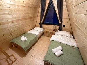 two beds in a small room with a window at Sno Valley Cottage in Sno