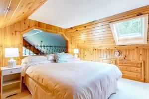 a bedroom with a large bed in a wooden wall at Marwood Lake Cottage in Wakefield