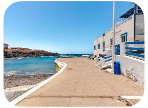 a sidewalk next to the ocean next to a building at Ocean front surf House El Cotillo in El Cotillo