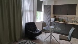 a kitchen with a chair and a glass table at Modern Studio Apartment with En-Suite in Peterborough