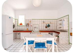 a kitchen with a white table and blue chairs at Ocean front surf House El Cotillo in El Cotillo