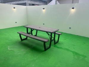 a picnic table and a bench on a green floor at The Sailor beach House Just 35 Minutes from Panama City! in Vacamonte