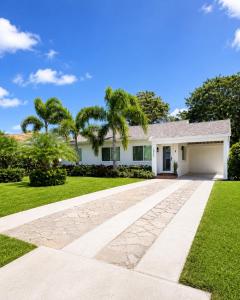 a house with a driveway and palm trees at Tropical Oasis 3 Bedroom House with Hot Tub West Palm Beach in West Palm Beach