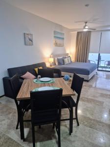 a living room with a couch and a table and a bed at Tu estancia perfecta - ubicación y privacidad in Playa del Carmen