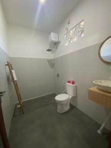 a bathroom with a white toilet and a sink at Datang Kemari Bungalow in Gili Islands