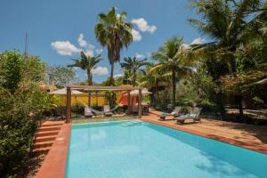 ein Schwimmbecken mit Schaukel und Palmen in der Unterkunft The Pickled Onion Hotel & Restaurant Uxmal in Santa Elena