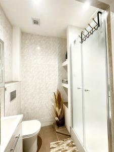 a white bathroom with a shower and a toilet at Apartment by the lake in Píšťany