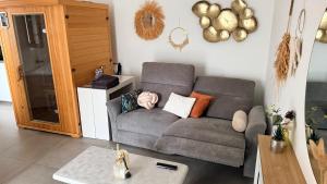 a living room with a couch and a table at SPA JUNGLE in Le Mesnil-Saint-Denis