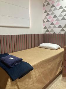 a bed with a blanket and a pillow on it at Casa completa e confortável in Leopoldina