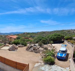 a blue car parked in a parking lot at Casa SILMAGA in La Maddalena +7 photos