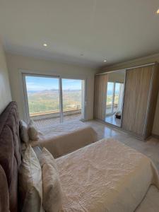 a large bedroom with two beds and a large window at Villa Beni Mejmel avec vue exceptionnelle in Tangier +101 photos