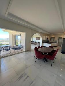 a large living room with a table and chairs at Villa Beni Mejmel avec vue exceptionnelle in Tangier