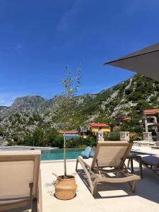 a patio with a table and chairs and a tree at Azure Boka in Trojica
