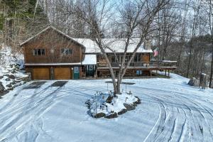 a cabin in the snow with a tree in the yard at Ski Bike the East in Stowe