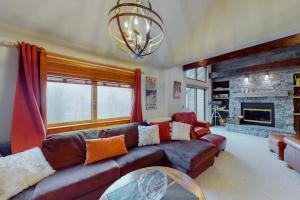 a living room with a couch and a fireplace at Sachem Slopeside - Okemo Trailside 21B in Ludlow