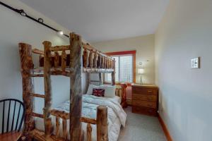 a bedroom with a wooden bunk bed in a room at Sachem Slopeside - Okemo Trailside 21B in Ludlow