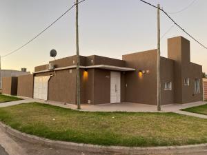 a brown building with two garage doors on a street at Casa quinta moderna, con pileta, parrilla, galería, 2 habitaciones, todos los servicios in San Nicolas