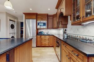 a kitchen with wooden cabinets and a counter top at Solitude Village J202 in Ludlow