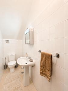 a white bathroom with a sink and a toilet at Dr. Cabral Barreto in Ponta do Sol +23 photos