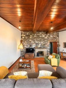 a living room with a couch and a stone fireplace at Dr. Cabral Barreto in Ponta do Sol