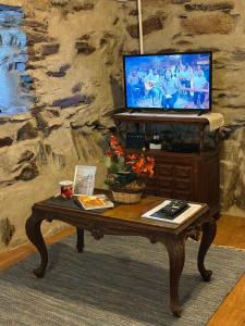a living room with a coffee table and a tv at Casa dos avós 23 in Castro Daire