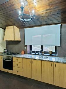 a kitchen with a sink and a stove at Casa dos avós 23 in Castro Daire