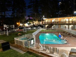 a swimming pool in front of a building at night at Cedar Inn & Suites in South Lake Tahoe