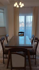 a dining room with a table and chairs and a window at Orges Apartament in Struga +1 photo