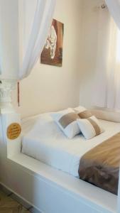a white bedroom with a bed with white sheets and pillows at Hammamet Studio Hafsya in Hammamet +16 photos