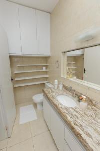 a bathroom with a sink and a toilet and a mirror at Pousada Casa da Adriana in Fortaleza +41 photos