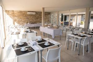 a restaurant with white tables and white chairs at Nova pampa apart&spa in Mar de las Pampas