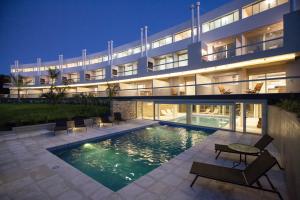a building with a swimming pool in front of it at Nova pampa apart&spa in Mar de las Pampas