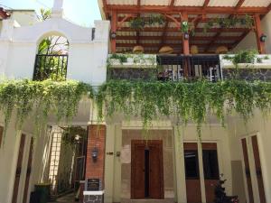 a building with a balcony with plants on it at Balmoral House Ambarukmo in Yogyakarta