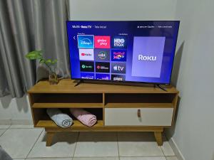Ein Fernseher steht auf einem hölzernen Unterhaltungsmöbel. in der Unterkunft Kitnet NOMAD in Barão de Cocais