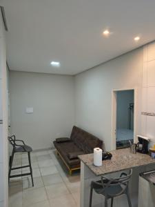 ein Wohnzimmer mit Sofa, Tisch und Stühlen in der Unterkunft Kitnet NOMAD in Barão de Cocais