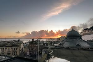 a view of a city with a sunset in the background at Stylish Harbourfront Apartment in Torquay