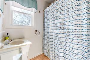 a bathroom with a sink and a shower curtain at Gloucester Coastal Gem in Gloucester +41 photos