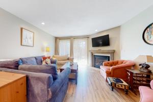 a living room with two couches and a fireplace at Nordic Wilderness Lodge in Bartlett