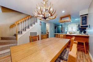 a dining room with a wooden table and a chandelier at Nordic Wilderness Lodge in Bartlett