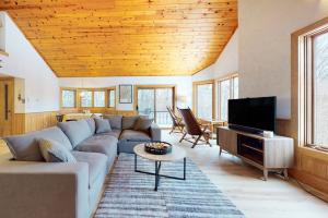 a living room with a couch and a tv at White Mountain Chalet in Bartlett