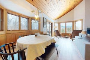 a dining room with a table and a couch at White Mountain Chalet in Bartlett