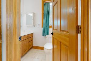 a bathroom with a toilet and a sink and a window at Life on the Lake in Colchester +38 photos