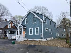 a blue house with a porch and a house at Beau in Gloucester