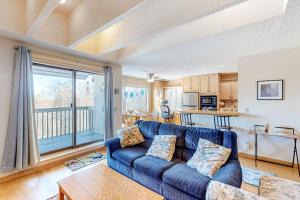 a living room with a blue couch and a kitchen at Snowside 20 in Waitsfield
