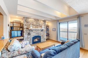 a living room with a couch and a stone fireplace at Snowside 20 in Waitsfield
