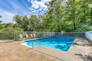 a swimming pool with two chairs and a fence at Snowside 20 in Waitsfield